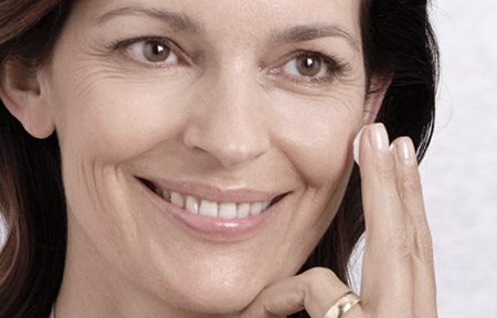 Donna che si applica la crema sul viso