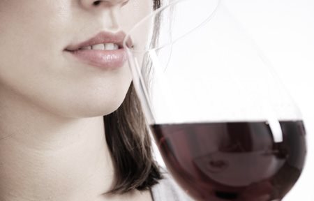 Donna che beve un bicchiere di vino rosso