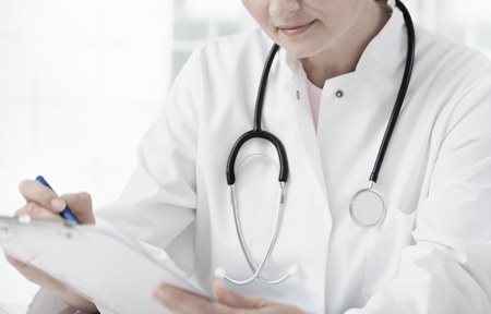 Medico con uno stetoscopio intorno al collo, che sta scrivendo qualcosa