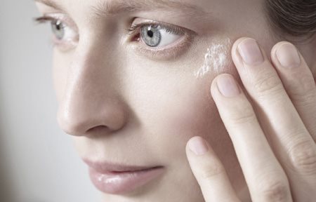 Donna che si tocca il viso con la mano