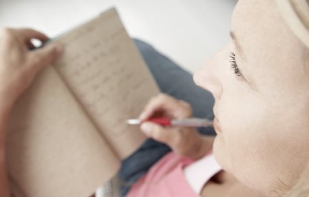 Donna che scrie qualcosa in un blocco di appunti
