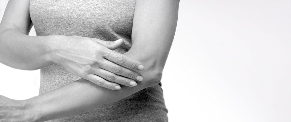 Donna che si tocca il braccio sinistro