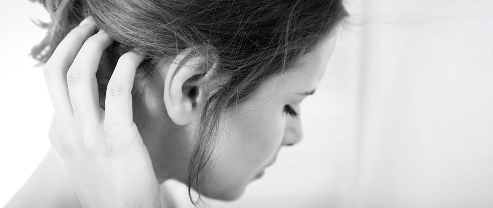 Donna a disagio, che si tocca il cuoio capelluto