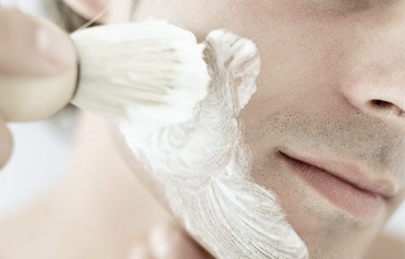 Uomo che applica la crema da barba sul viso