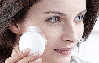 Donna che applica il Latte Detergente con un batuffolo di cotone