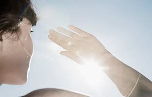 Donna che si protegge gli occhi dal sole con la mano destra