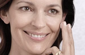 Donna che si applica la crema sul viso