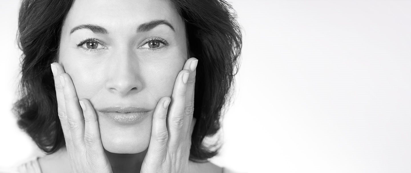 Donna di mezza età che si tocca le guance con entrambe le mani