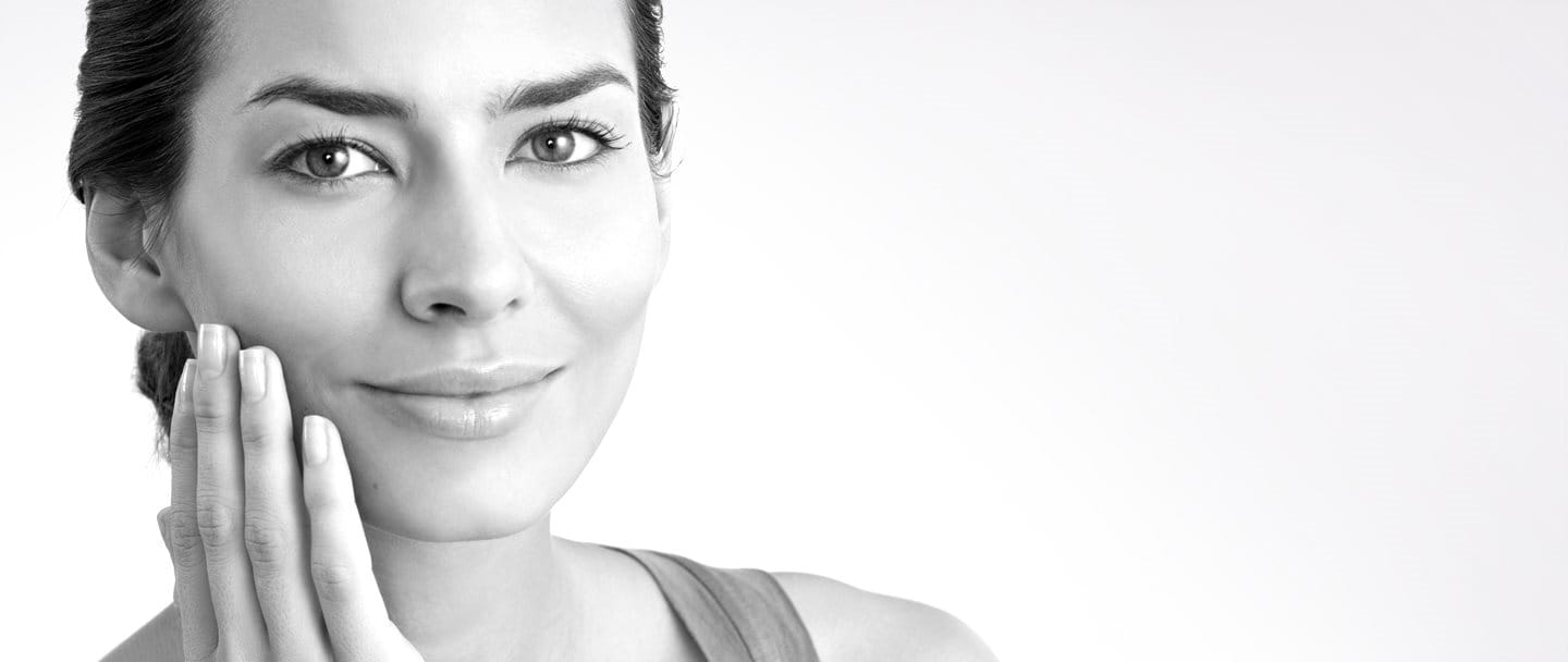 Donna di mezza età che si tocca la guancia destra con la mano