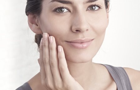 Donna che applica la crema sul viso