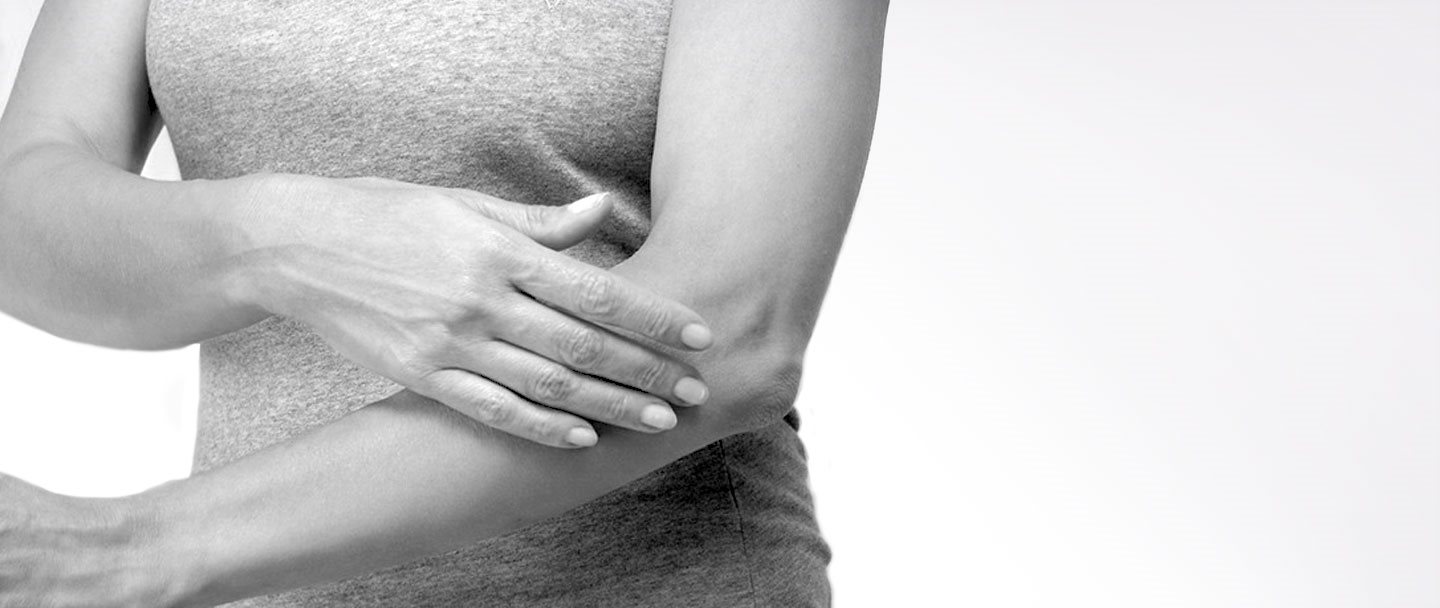Donna che si tocca il braccio sinistro
