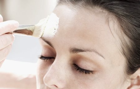 Il peeling viene applicato sul viso di una donna con un pennello